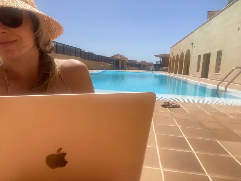 digital nomad working beside the pool